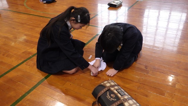 体育館床の墨の汚れを拭く５年生