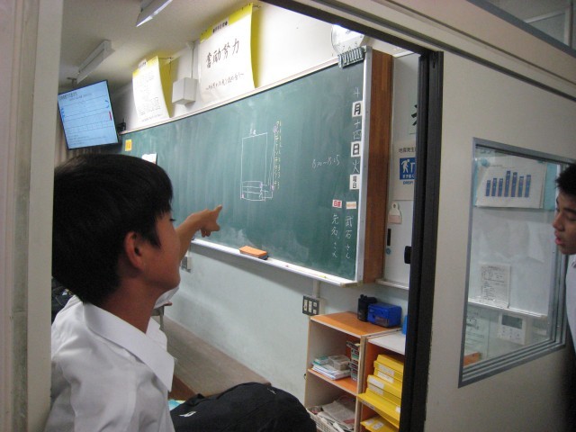 １－１　リーダーが黒板の図を参考に、廊下にいるクラスメートに指示を出しています。