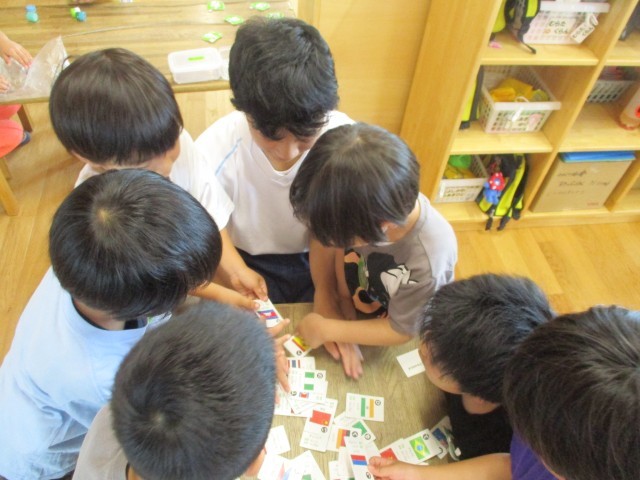 ４～５歳児の部屋で世界の国旗の色を見て、遊んでいます。また、１歳児の部屋ではお歌遊びをしています。